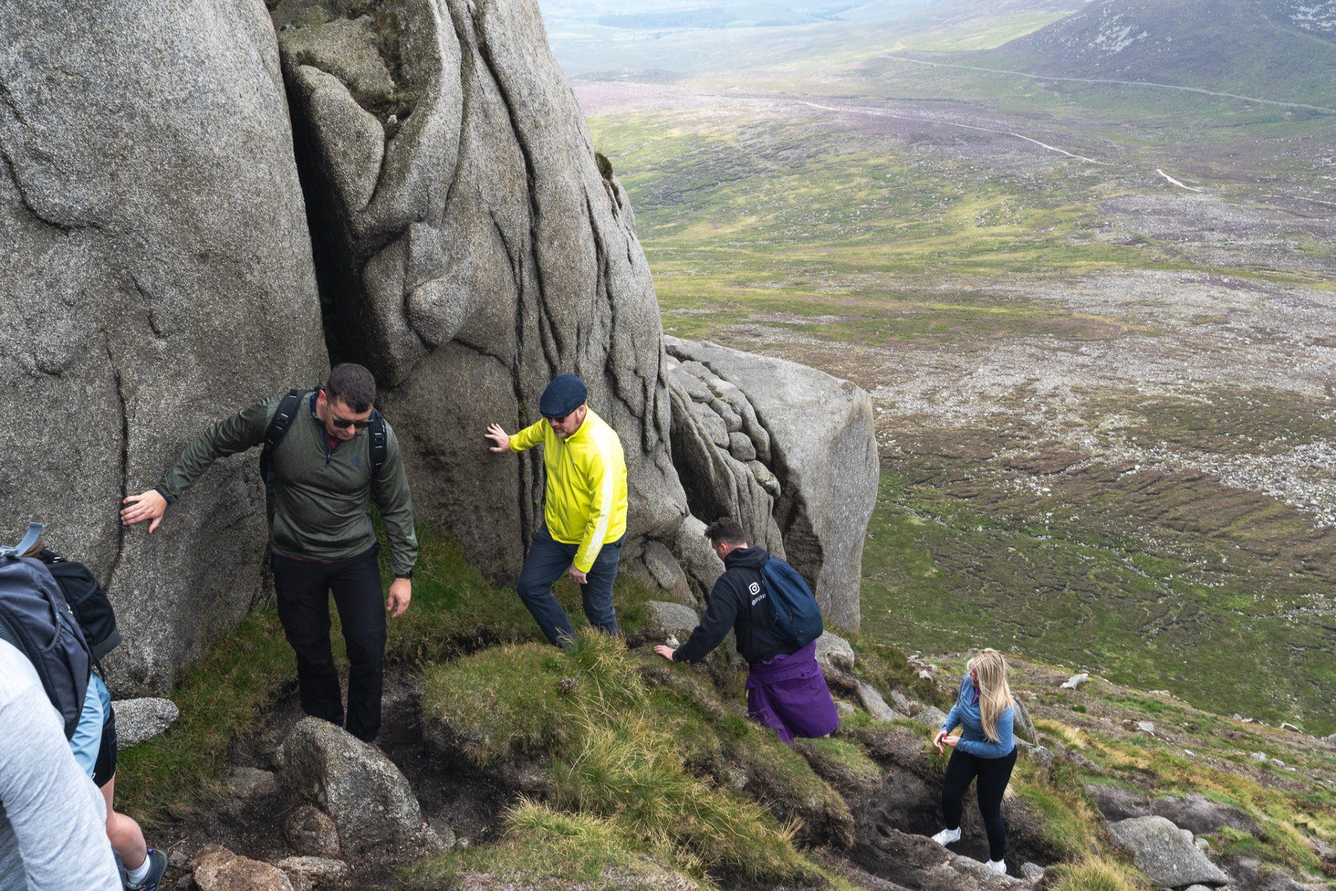 Members scrambling over granite rock high in the Mournes
