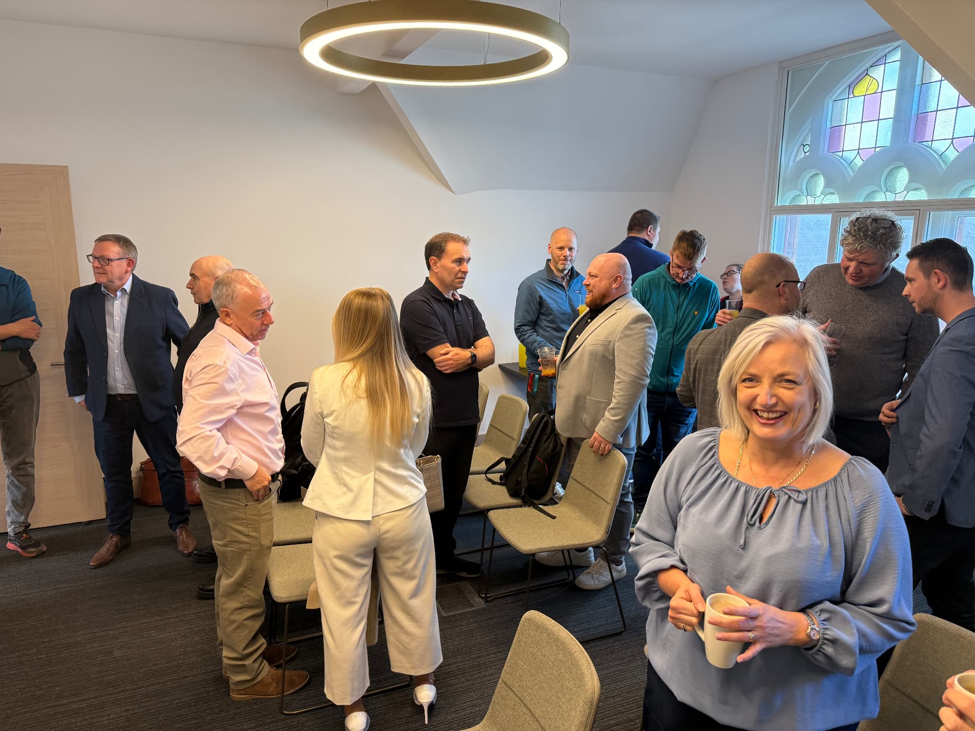 Growth Network members chatting in small groups over coffee before a gathering