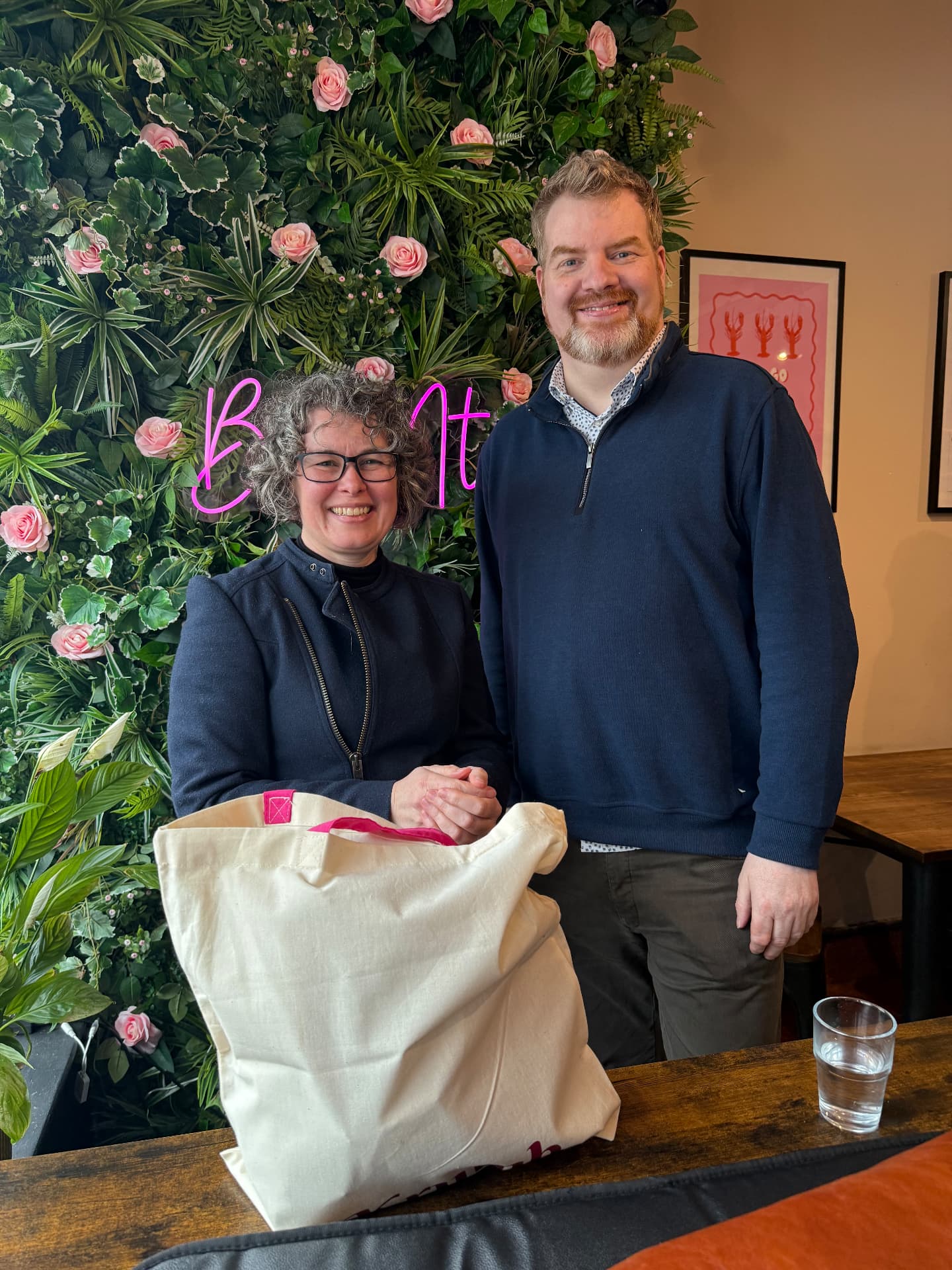 Two members with a Growth Network tote bag at a gathering